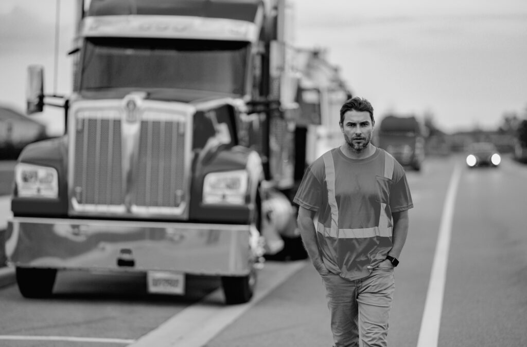 Esta imagen tiene un atributo ALT vacío; su nombre de archivo es men-driver-near-lorry-truck-truck-driver-safety-vest-near-truck-trucker-trucking-owner-transportation-industry-vehicles-handsome-man-driver-front-truck-1024x676.jpg